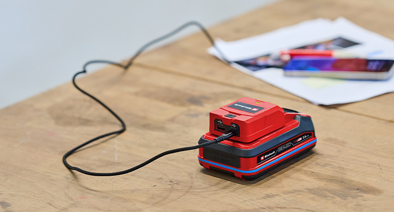 der Einhell Akku-USB-Adapter lädt ein Smartphone