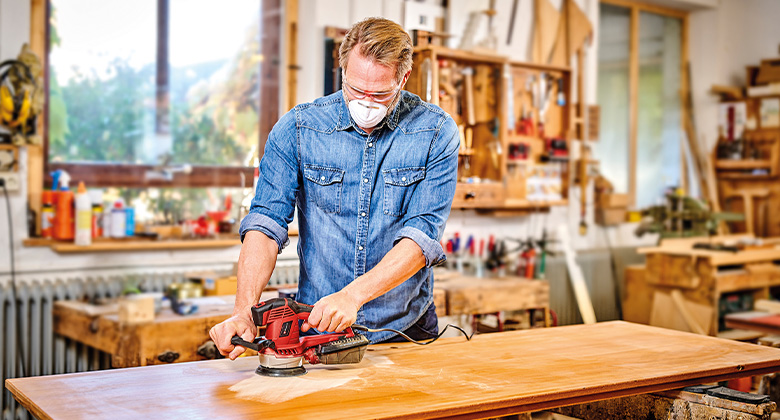 Mann schleift Holz mit optimierter Drehzahl