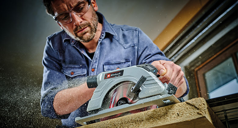  Ein Mann sägt Holz mit einer Akku-Handkreissäge