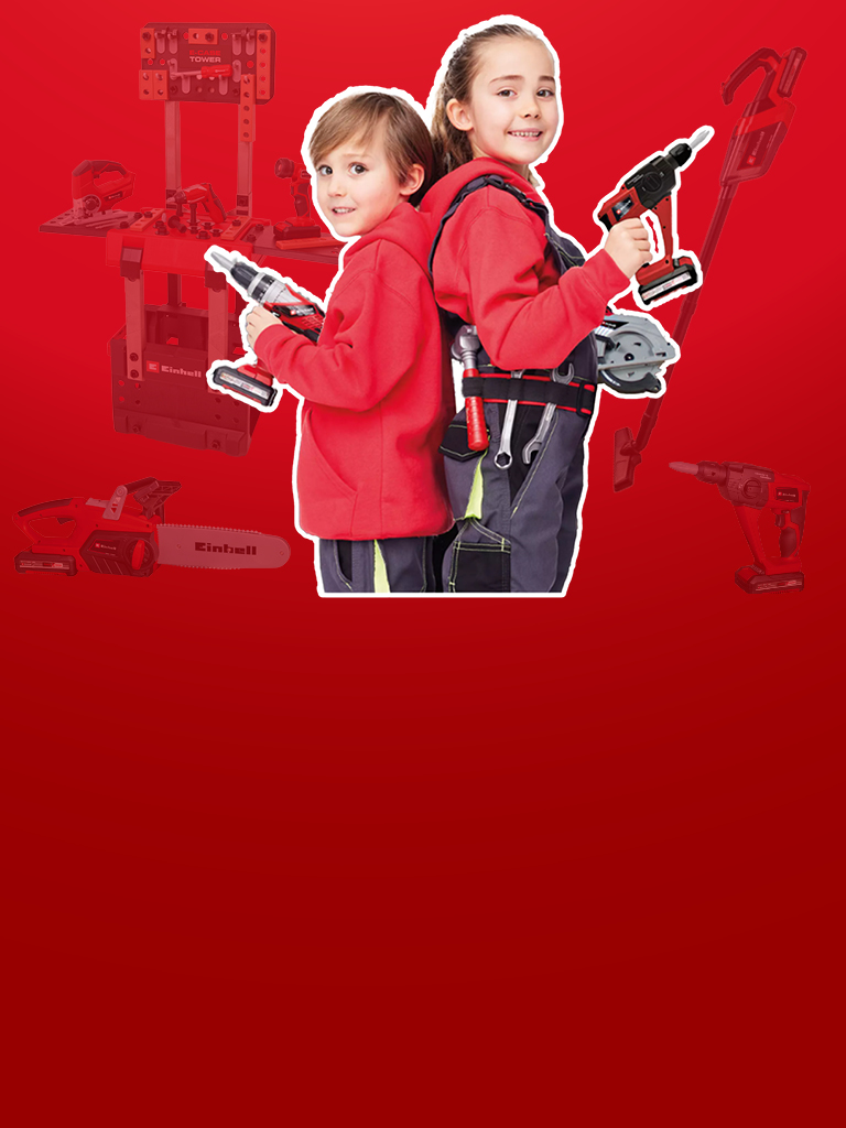 Zwei Kinder in roter Kleidung mit Einhell Spielzeugwerkzeugen und Werkbank vor rotem Hintergrund.