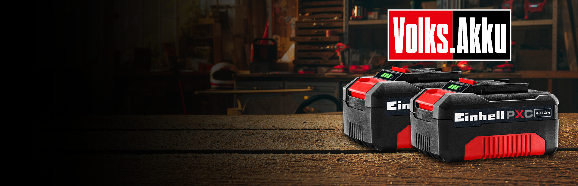 In the background, a workshop is visible. In the foreground, there are two Einhell 4.0 Ah PXC batteries. The text “Volks.Akku” appears in the image.