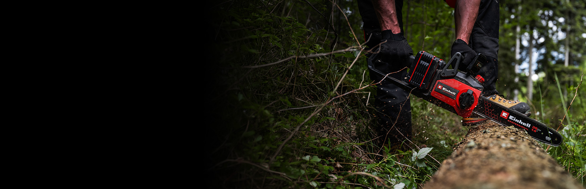 ChatGPT said: A person is using a red-and-black cordless chainsaw to cut through a fallen tree in a dense forest. The scene shows wood chips flying as the saw cuts into the trunk.