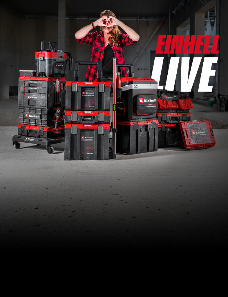 Person steht hinter gestapelten Einhell Werkzeugkoffern in Baustelle und formt Herz mit Händen, daneben Schriftzug „EINHELL LIVE“.
