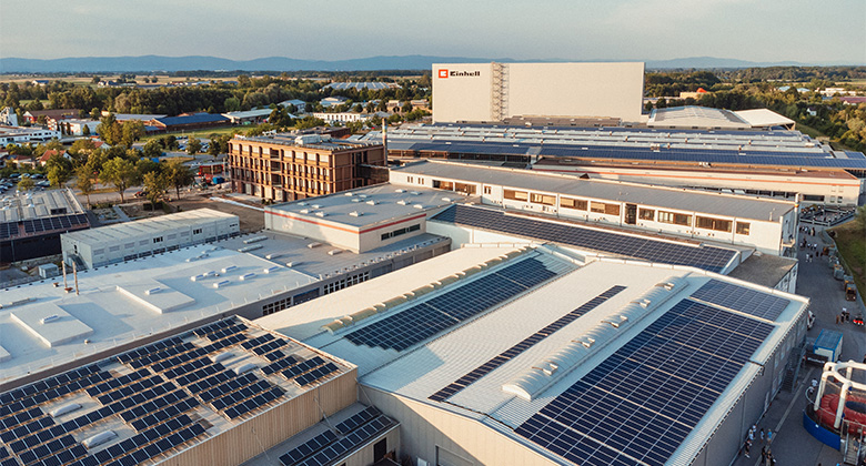 Aerial view of the Einhell company premises with numerous factory halls whose roofs are extensively covered with photovoltaic systems.