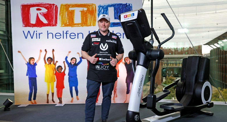 a man standing next to a cross trainer