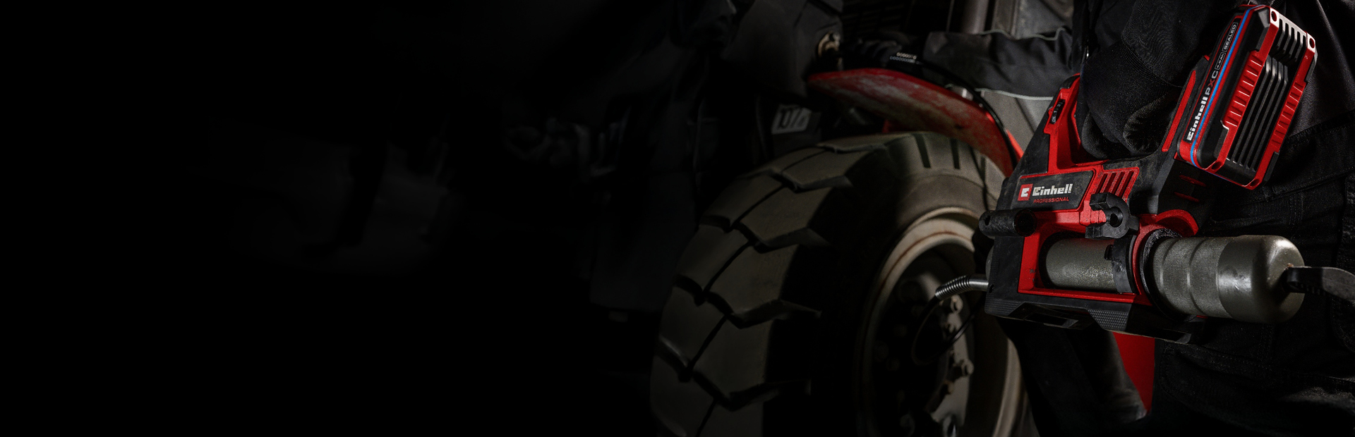 Person nutzt eine Einhell Akku-Fettpresse zur Schmierung eines Fahrzeugteils.