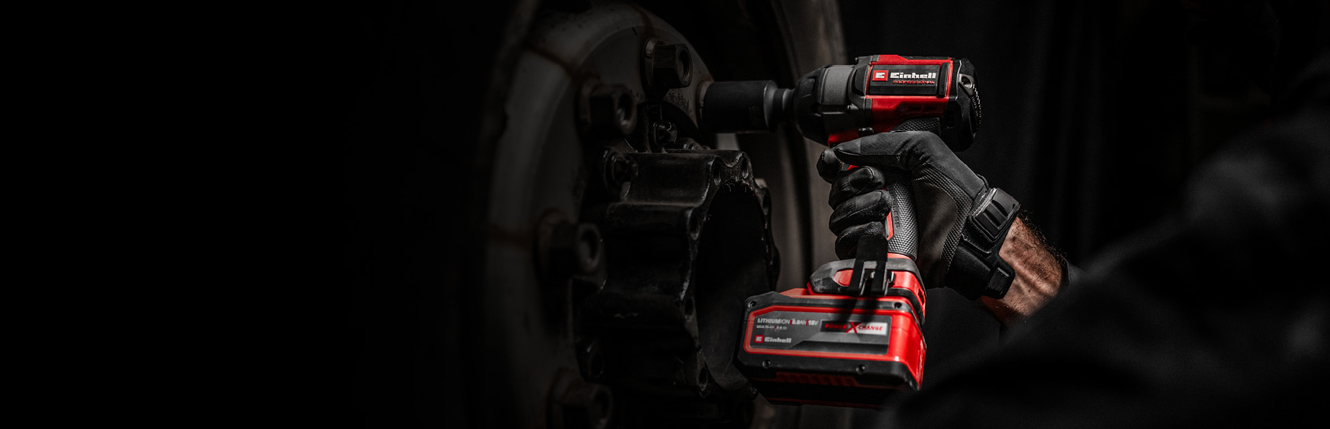 Mechaniker nutzt einen roten Einhell Akkuschlagschrauber, um eine Radschraube zu lösen.