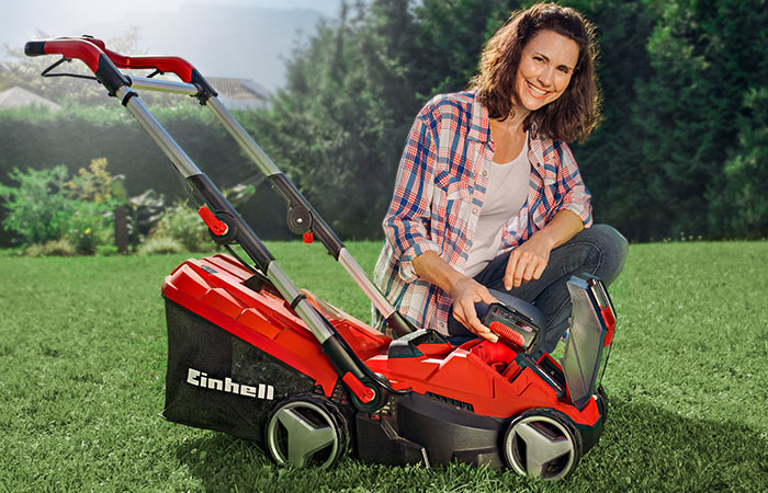 woman with a cordless lawn mower