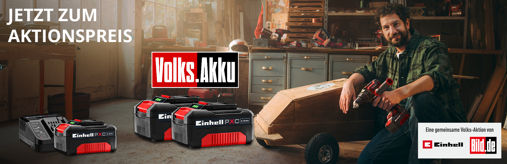 Promotional image with the text “Jetzt zum Aktionspreis” showing several Einhell Power X-Change batteries, including a charger and three 18V 4.0Ah batteries. A man with a cordless drill sits beside a homemade wooden vehicle.